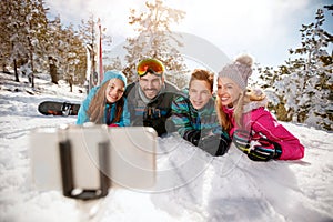 Family enjoying winter vacations in mountains and making selfie