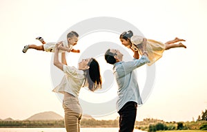 A happy family enjoys a playful moment in a summer field