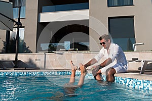 Happy family enjoys vacation in luxury house with pool. Father spends time with son having fun in pool. Selective focus