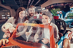 Happy family, enraptured son sitting on toy car photo