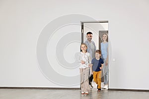 Happy family entering in their new apartment on moving day. Space for text