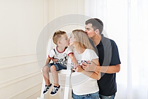 Happy family expecting new baby. Pregnant woman kiss the little son.