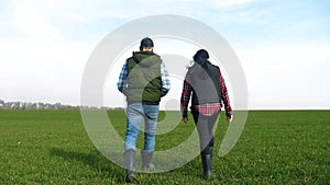 happy family of farmers teamwork a red neck works go on the green field. man and girl farmer are studying eco farming