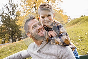 Happy family father and child boy in the autumn leaf fall in park