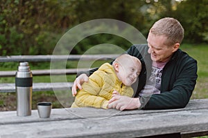 Happy Family: Father And Child Boy Son Playing And Laughing In Autumn Park, Sitting On Wooden Bench And Table. Father