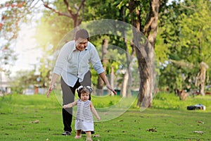 Happy family father and child daughter playing and laughing outdoor park