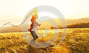 Happy family father and child daughter run with kite on meadow