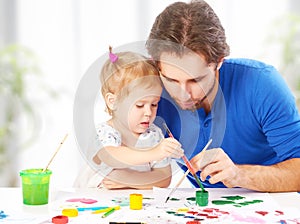 Happy family father and child daughter together draw paints
