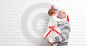 Happy family father and child with gift in Christmas kiss