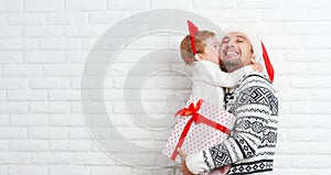 Happy family father and child with gift in Christmas kiss