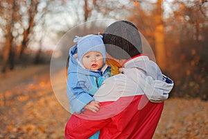 Happy family father and child girl daughter playing and in autumn park man posing backwards holding baby girl among colorful