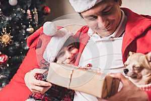 Happy family father and child giving Christmas gift at home