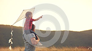 Happy family father and child on meadow with a kite in summer