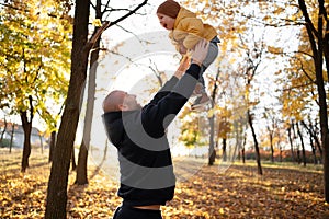 Happy family father and child son playing and laughing on autumn walk. Family, childhood, season and people concept.