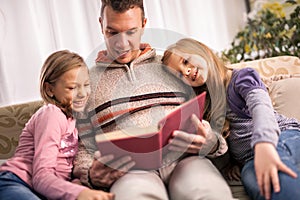 Happy family father and children reading a book