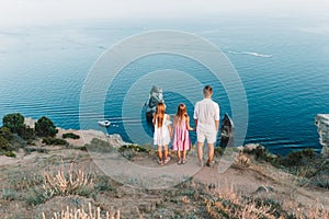 Happy family of four walking in the mountains on the sunset