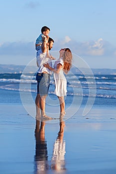 Happy family - father, mother, baby son on sea beach holiday