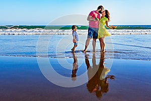 Happy family - father, mother, baby on summer beach vacation