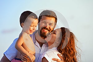 Happy family - father, mother, baby on sunset beach