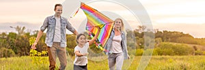 Happy family father, mother and child daughter launch a kite on nature at sunset