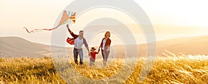 Happy family father, mother and child daughter launch a kite on