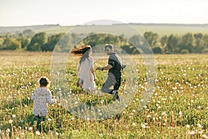 Happy family father, mother and child daughter on nature at sunset