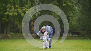 Happy family: Father, Mother and child - little girl walking in autumn park: dad going to the daughter