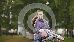 Happy family: Father, Mother and child - little girl walking in autumn park: playing at the grass