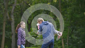 Happy family: Father, Mother and child - little girl walking in autumn park: playing outdoor