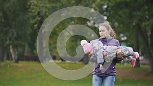 Happy family: Father, Mother and child - little girl walking in autumn park: running and playing at the grass