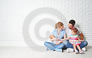 Happy family father mother and children at empty wall