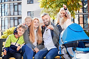 Happy family - father, mother and children having fun together on playground.