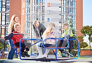 Happy family - father, mother and children having fun together on playground.