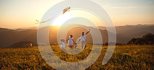 Happy family father, mother and children launch kite on nature