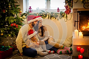 happy family father mother and children sitting by fireplace on Christmas Eve