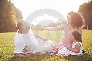 Happy family, father of mother and daughter of baby in the nature at sunset