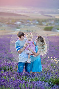 Happy family of father mother and daughter enjoy vacation on field of lavender flowers. Sensual scene of family happyness