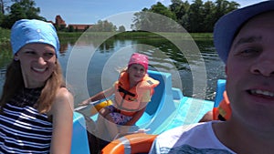 Happy family father,mother,little boy and girl sailing on boat. Gimbal selfy