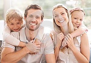 Happy family, father and mother portrait with children relaxing, hugging and enjoying fun quality time at home. Smile