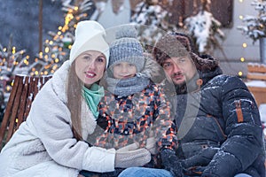 Happy family father and mother with son in winter nature. Portrait attractive caucasian parents hugging cute child in snowy forest