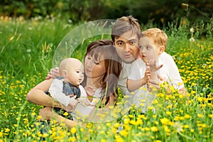 Happy family father, mother and sons relaxing in the park