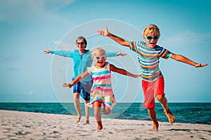 Happy family -father with son and daughter run play at beach