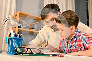 Happy family. Father and son doing homework together