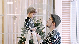 Happy family of father and son near Christmas tree at home