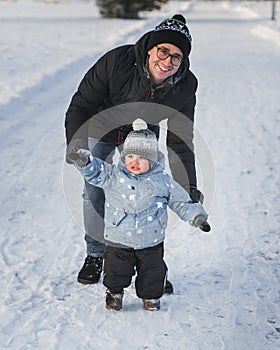 Happy family father and son walking in winter park