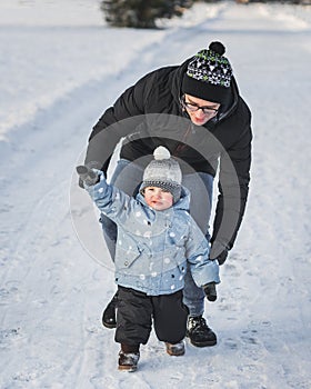 Happy family father and son walking in winter park