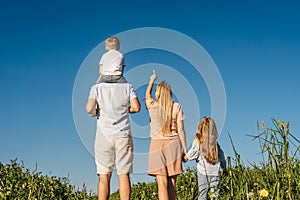 Happy family in field. Back view