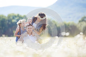 Happy family on a field of blooming daisies