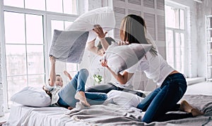 The happy family fighting with pillows.