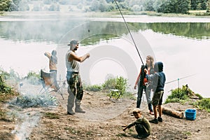 A happy family is fishing on the bank of a river or lake. Spending time together, family time, family vacation